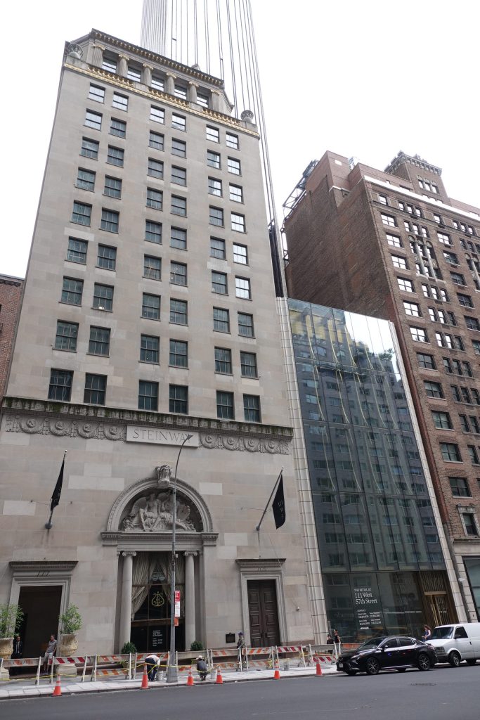 The Steinway Hall and adjacent glass retail space located at 111 W. 57 St., a tall building with many windows